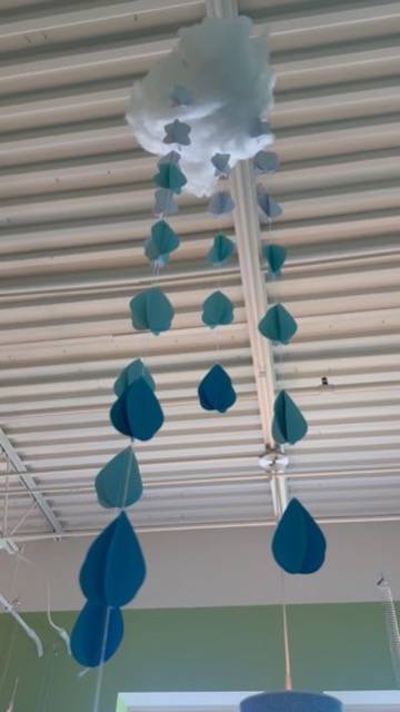 Handmade paper cloud and raindrop mobile hanging from the ceiling